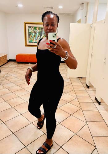 Person wearing a fitted achromatic  outfit and sandals, taking a reflector  selfie successful  a stylish country   with creation  and modern   lighting