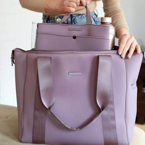 model inserting items into lilac weekender bag