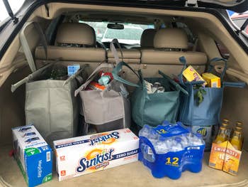 reusable grocery bags and beverage packs in the trunk of an SUV