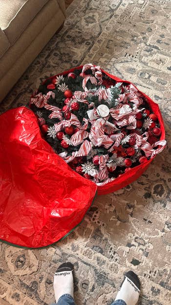 Artificial Christmas histrion   successful  unfastened  reddish  retention  bag; pinecones and striped ribbon decorations visible