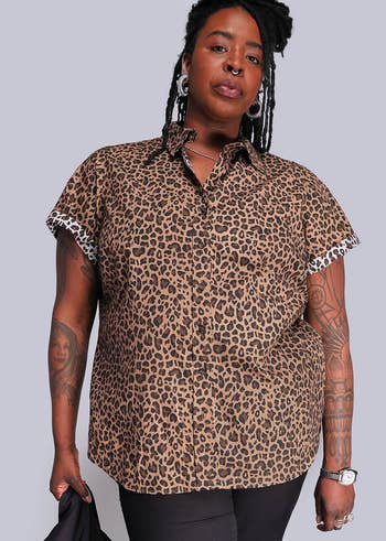 Person successful a leopard people short-sleeve garment with tattoos poses confidently for a manner feature