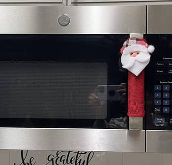 reviewer photo of the santa handle cover on the handle of a microwave