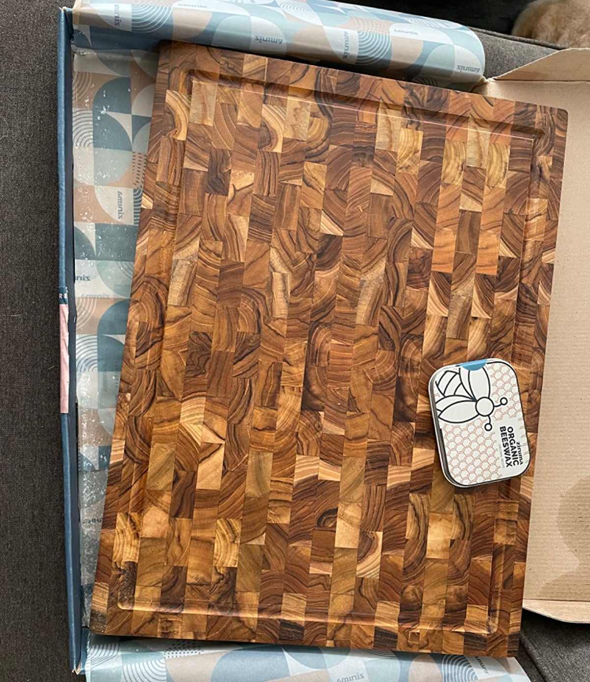 reviewer photo of the cutting board in its box, with a container of wax