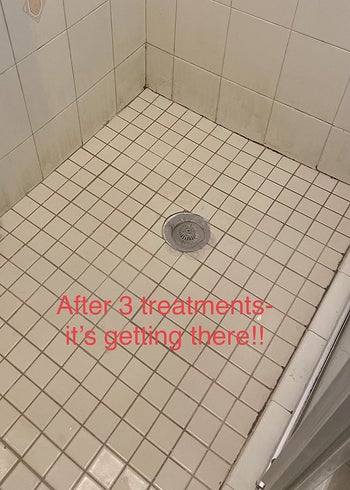 reviewer showing how clean the shower floor is after using the product three times