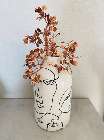 a reviewer photo of the white vase with black line work 