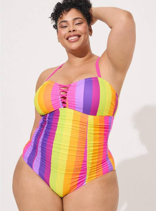 model wearing the muted rainbow one-piece with a lattice front design