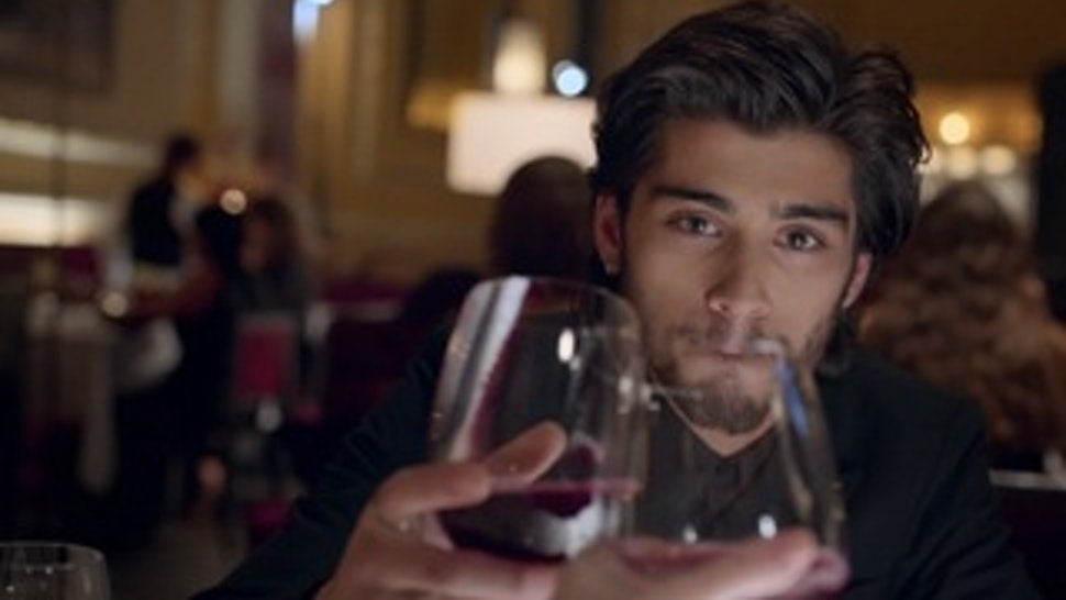 Zayn clinks a wine glass in the "Night Changes" video