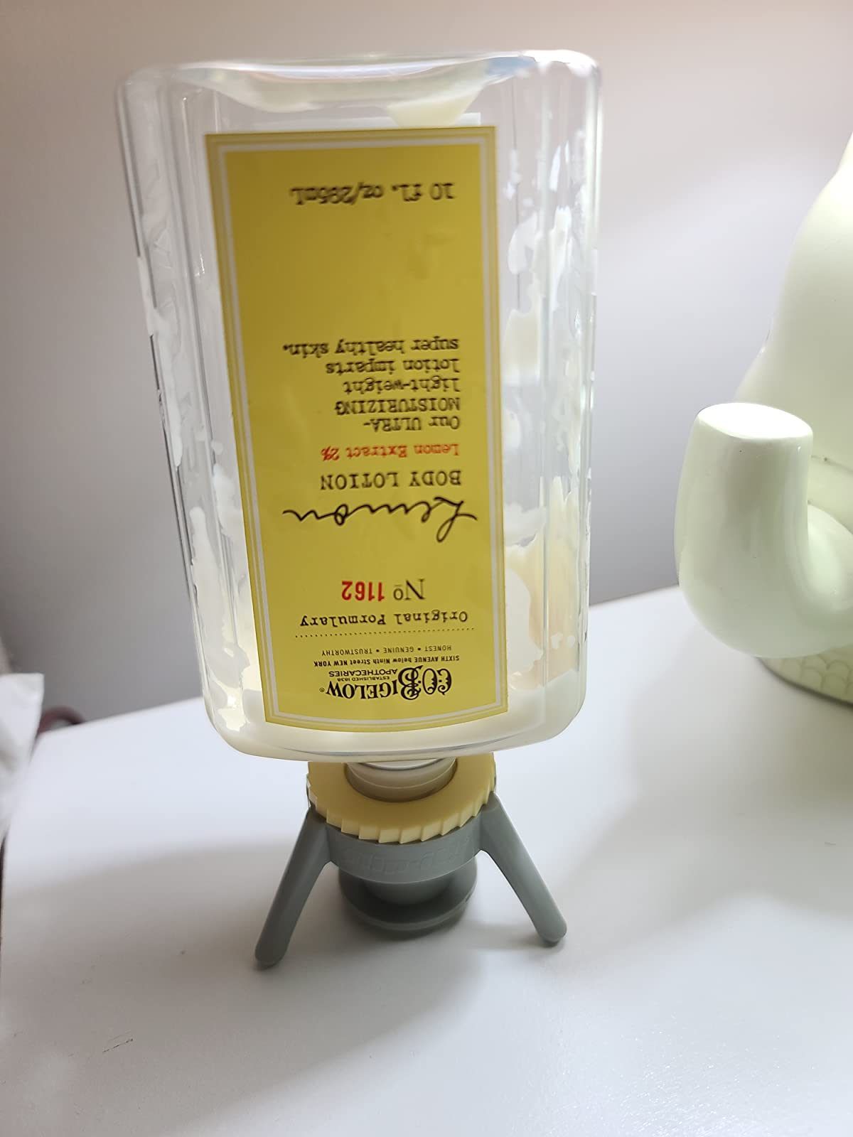 reviewer's gray bottle emptying can propping up an upside down body lotion bottle