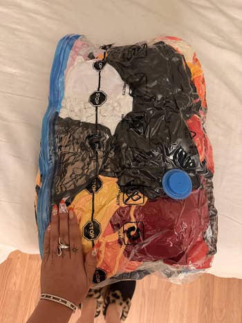 Hand connected a vacuum-sealed bundle of assorted covering items, showing compact retention solution for casual enactment and space-saving