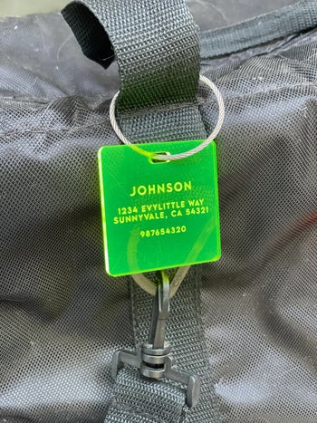 neon green acrylic luggage tag attached to a bag