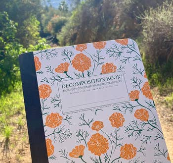 the composition notebook with orange flower son the color 