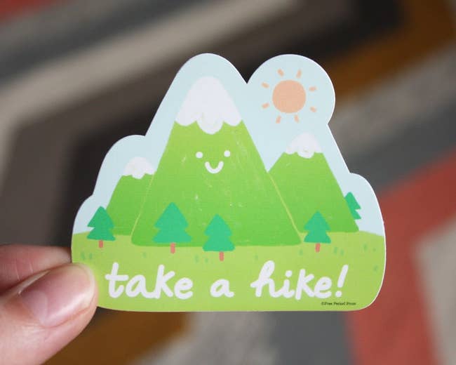 green sticker featuring a smiley mountain range and the words 