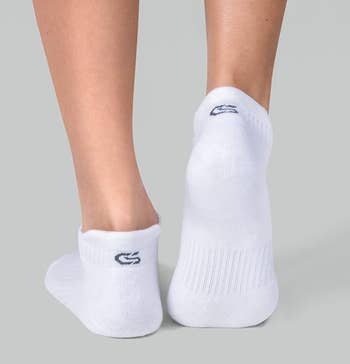Person standing in white, low-cut socks