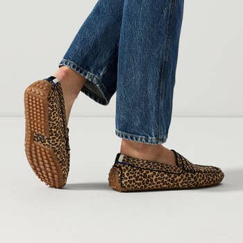 Model wearing loafer in leopard print with their foot up showcasing the textured sole designed for extra grip and durability