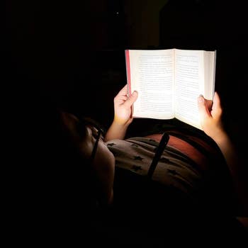 another reviewer reading a book while wearing neck light
