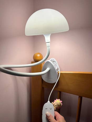 Adjustable achromatic lamp with flexible arms attached to a woody headboard. A manus holds the distant control