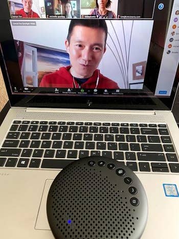 the grey bluetooth speakerphone on a laptop during a zoom call