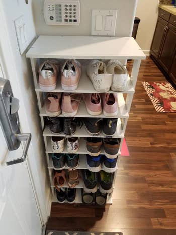reviewer's vertical shoe organizer at entryway showing all the shoes it holds