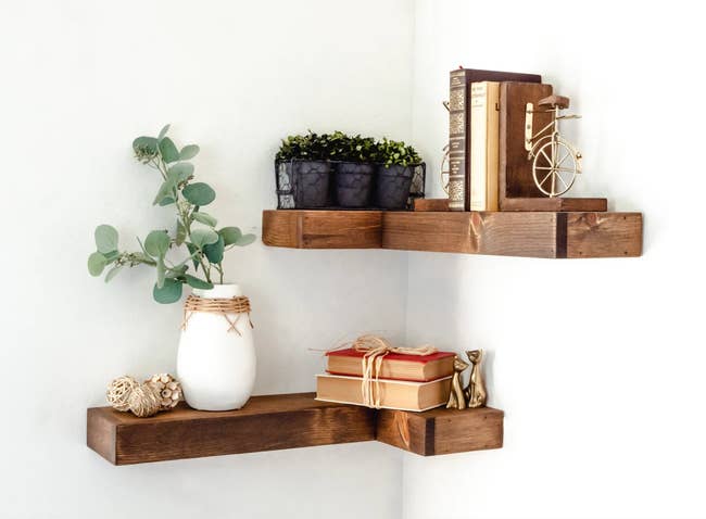 floating wooden corner shelves holding items like  plants and books