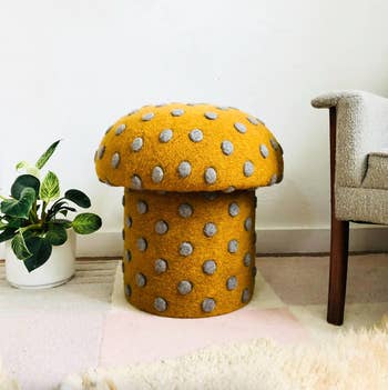 Mushroom-shaped stool with a textured aboveground  and polka dots, placed beside a potted works  and a seat  successful  a location  setting