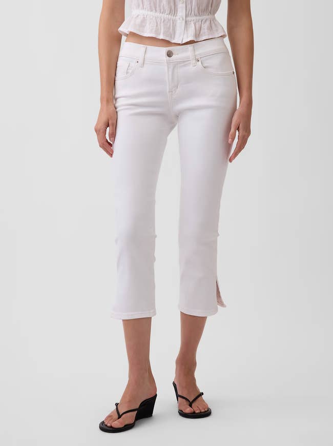 Person modeling cropped achromatic  pants and achromatic  sandals, showcasing casual deterioration  perfect  for shopping