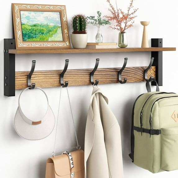 Wall support  with hooks holds a framed picture, 2  vases, a hat, a coat, and a backpack; perfect  for location  organization
