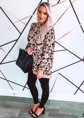 reviewer in the khaki leopard sweater with black leggings and heels