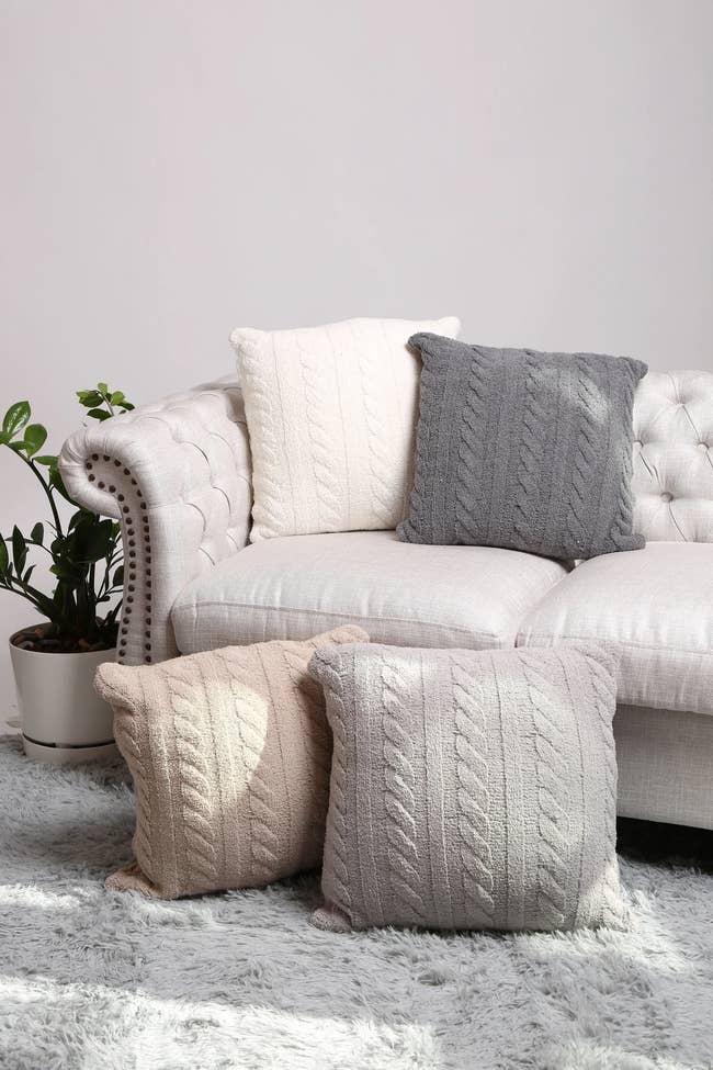 grey, white, and beige pillows on a couch