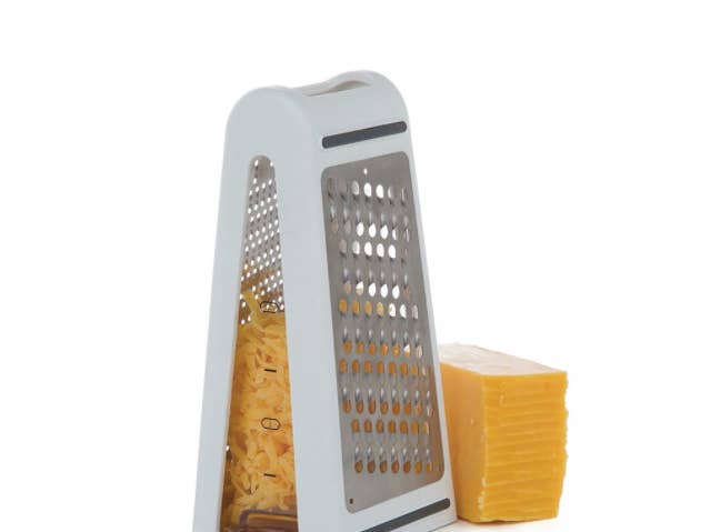 A grater with cheese in the middle and slices on the side