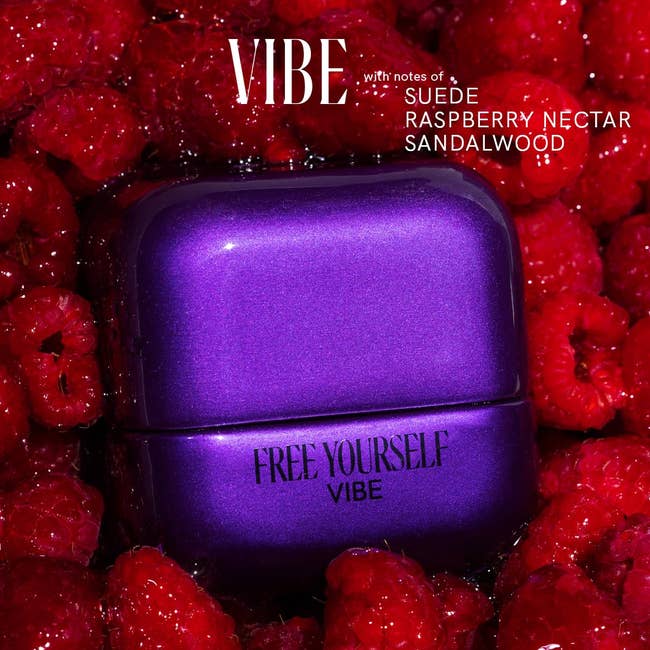 VIBE perfume vessel  surrounded by raspberries, featuring notes of suede, raspberry nectar, and sandalwood