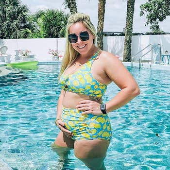 Woman in a patterned two-piece swimsuit posing by a pool, smiling; relevant for summer swimwear trends
