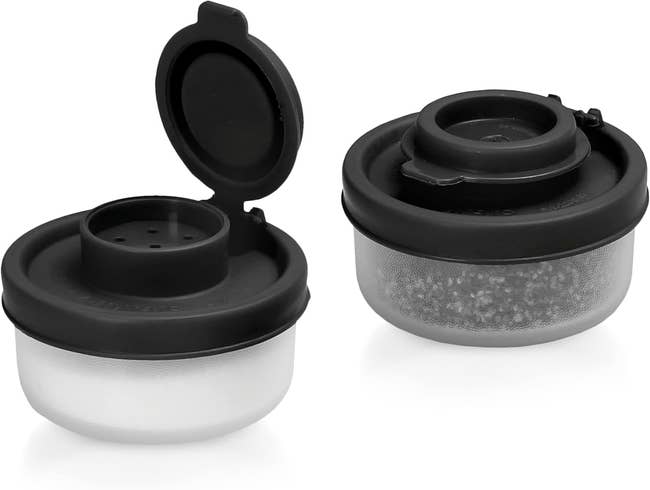 Two black plastic spice containers, one open showing holes for sprinkling and the other closed, designed for efficient kitchen storage and use