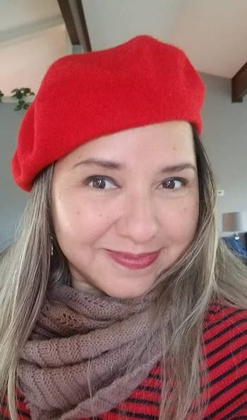 Reviewer wearing beret in red with a scarf and red striped shirt