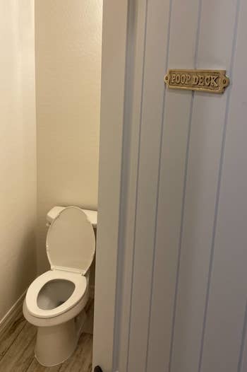 Bathroom doorway somewhat ajar with humorous
