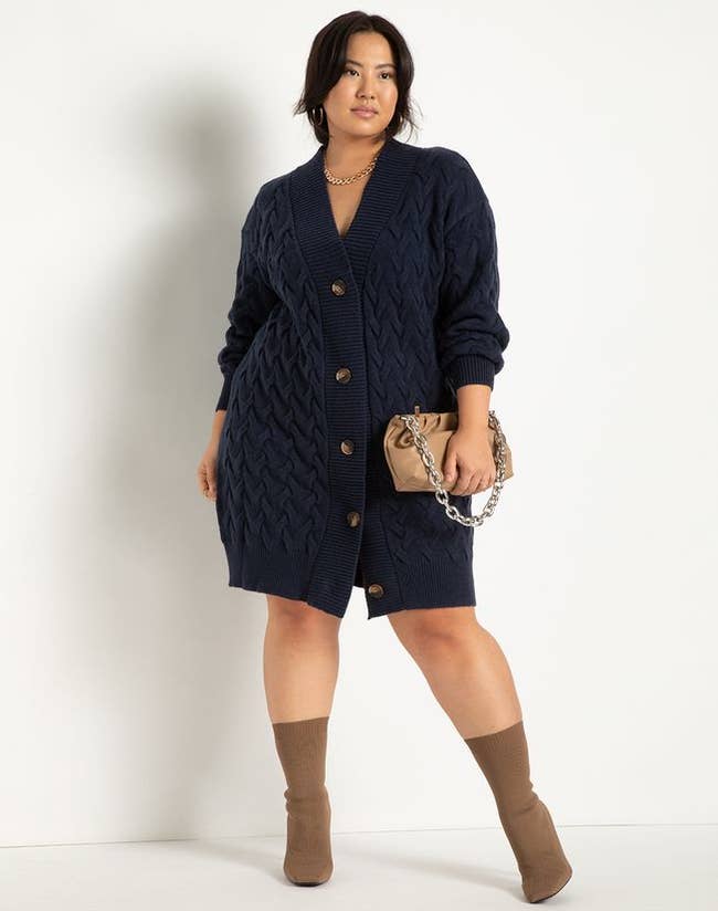 a model wearing the same cardigan dress in navy without a shirt underneath 