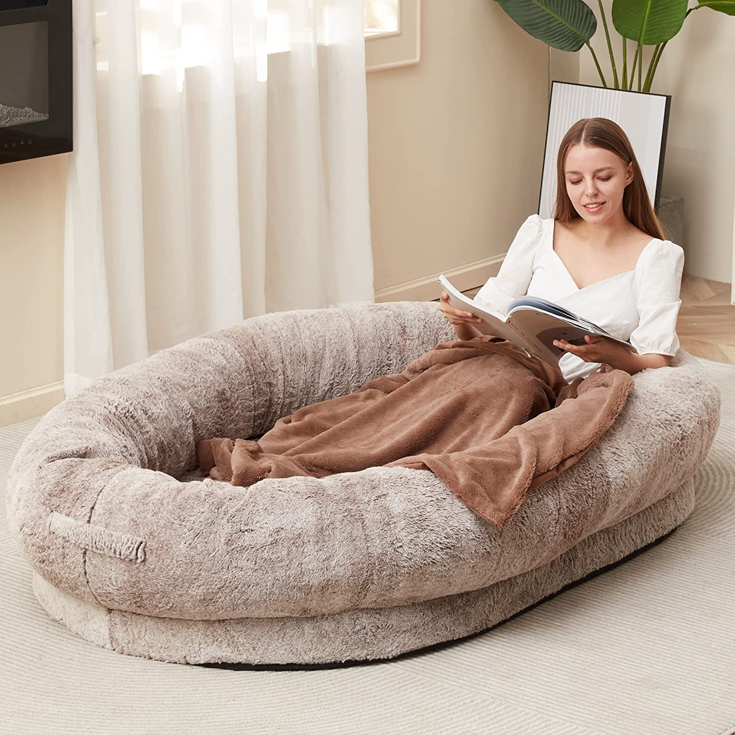 Model in a beige oval rimmed bed on the floor 