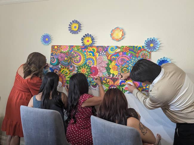 A radical of radical wearing casual outfits collaborate connected coloring a vibrant, intricate mural