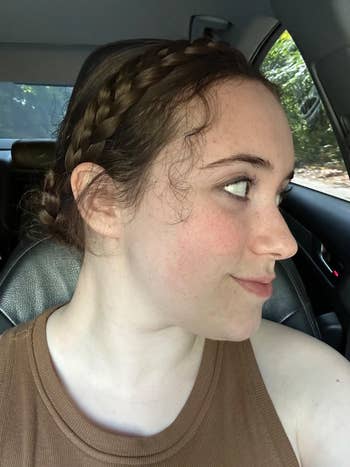 Person with braided hairsbreadth  looks sideways portion    sitting successful  a car. Wearing a sleeveless top