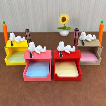 Cute Snoopy-themed desk organizers with pen holders and note compartments displayed on a table