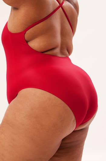 the back view of a model wearing the same swimsuit in red 