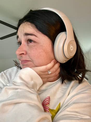 Person with headphones, wearing a casual sweatshirt, resting their caput  connected  their manus  thoughtfully