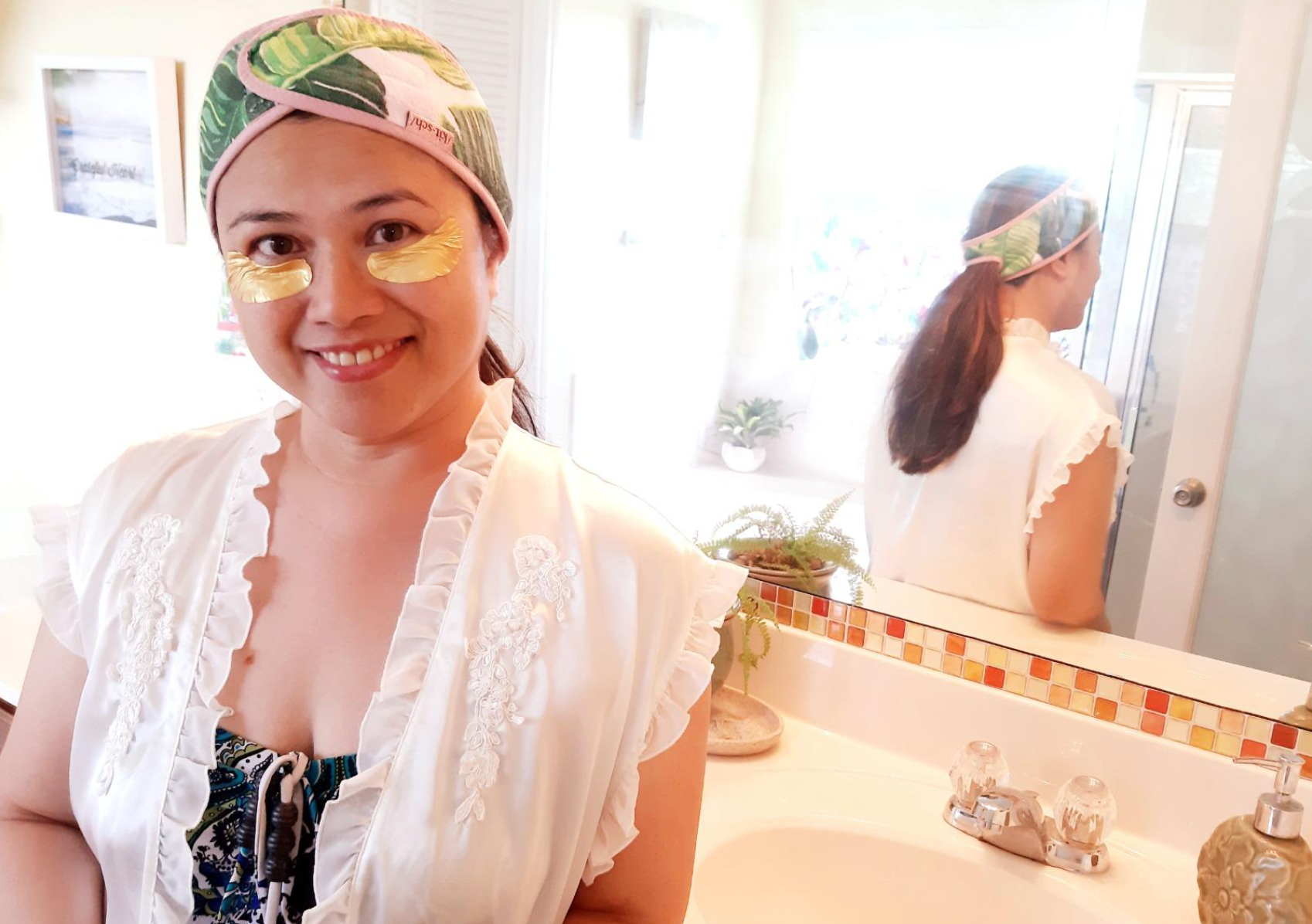 Reviewer with their hair pulled back by a pink and green band, showing reflection in back mirror that their ponytail is in the slit in the back 