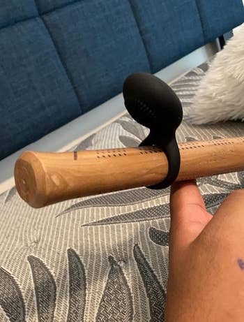 reviewer's black cock ring demonstrated on baseball bat