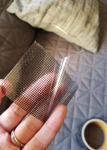 person holding a square of the repair tape