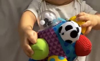 reviewer's baby holding the toy