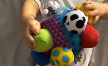 reviewer's baby holding the toy