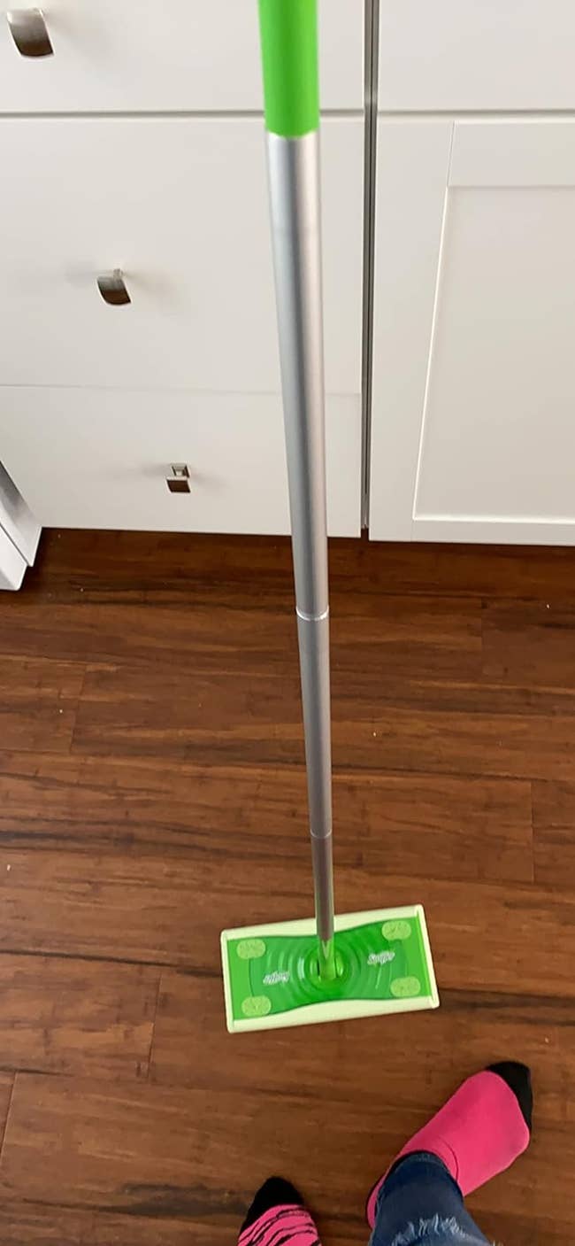 reviewer standing with their Swiffer 