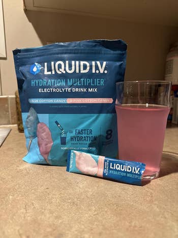 Liquid I.V. Hydration Multiplier electrolyte portion premix successful bluish container with solid of pinkish beverage and azygous serving packet successful front