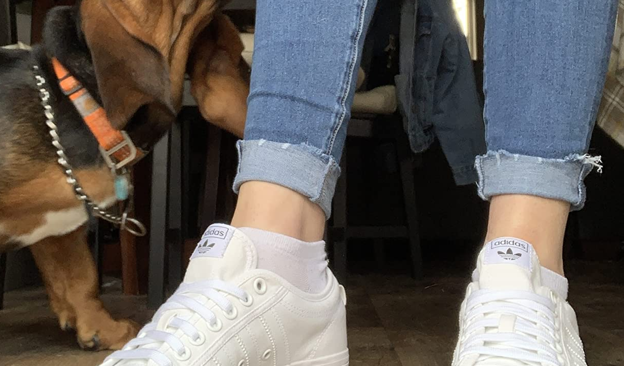 reviewer wearing a pair of all-white Adidas sneakers