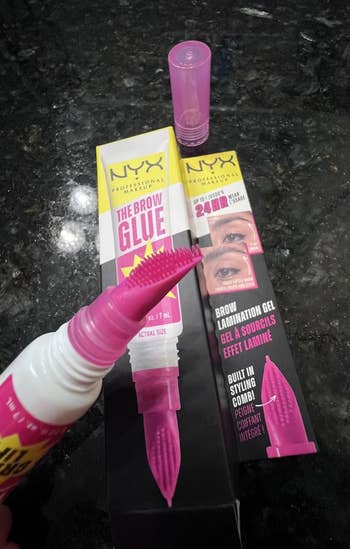 NYX Brow Glue packaging and applicator amusement   merchandise  features, promoting 24-hour clasp  and styling comb for confident, laminated brows